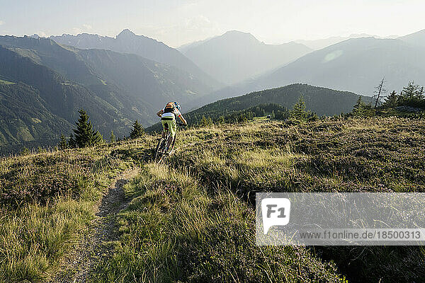 Rear view of mountain biker riding on uphill  Zillertal  Tyrol  Austria