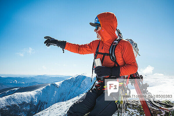 Ski mountaineer taking a break and drinking a hot beverage
