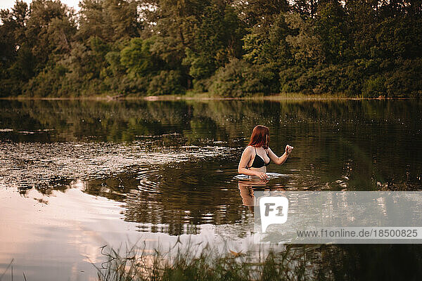 Woman in lake in forest