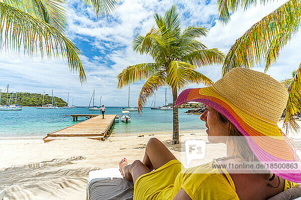 Woman relaxing on beach bed on white sand beach  Caribbean