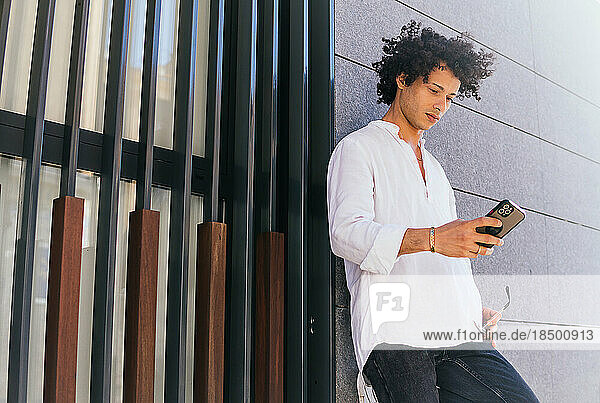 Stock photo of business man using his phone to send message outdoors