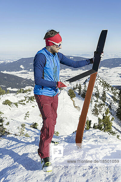 Man holding skis on mountain