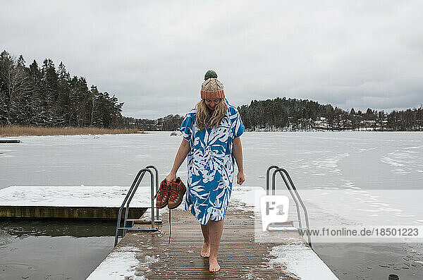 woman walking on a dock ready to go cold water swimming