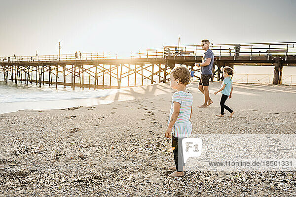 Dad playing with daughters at beach