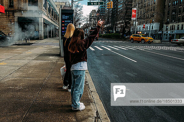 Teen girl hailing cab in New York city