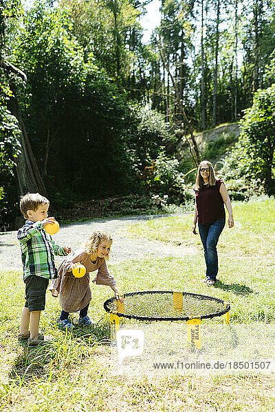 Children playing games together at a campsite while their mom watches