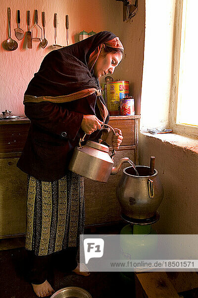 Woman cooks mid day meal on gas burner in Kabul.