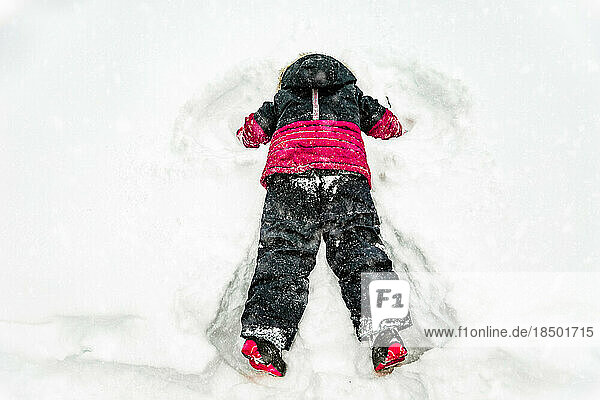 5 years old girl doing reverse angel on snow