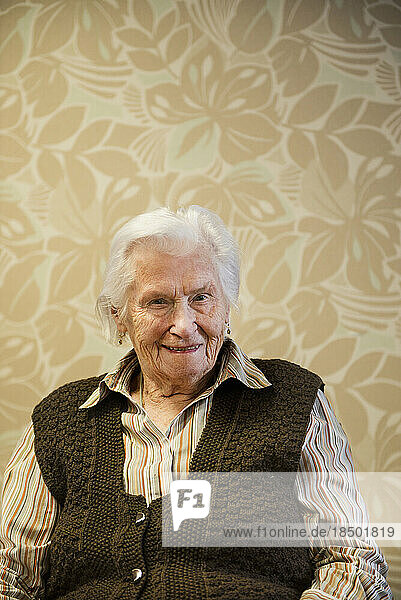 Portrait of a senior woman in front of wallpaper