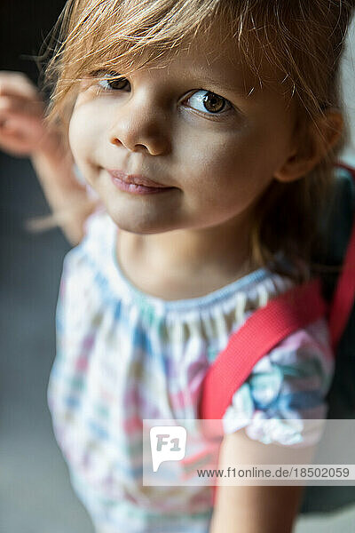 Close up of preschool aged girl standing outside