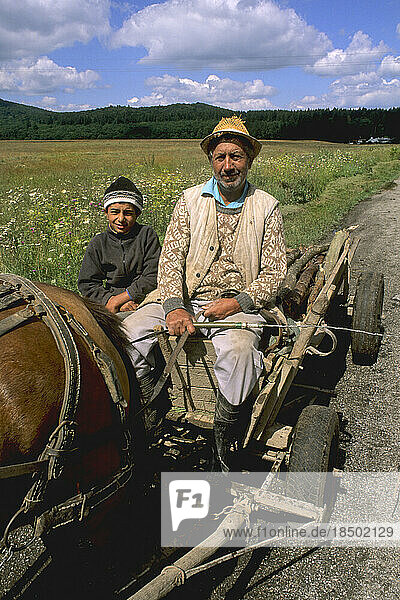 Man and son on wagon with horse in rural Macedonia