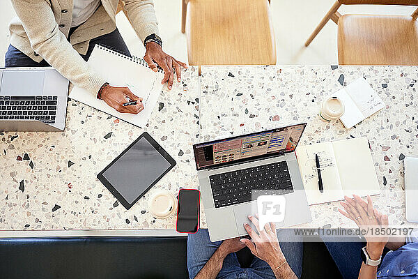 Directly above shot of business people working together in coffee shop