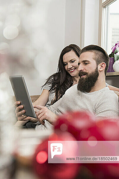 Couple watching digital tablet on sofa