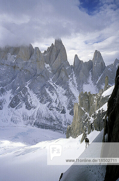 Climber on Cerro Torre's east face with the peaks of Aguja Poincenot  Aguja Rafael and Aguja Saint Exupery in the background.