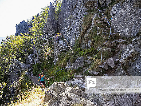 Women climbing up on narrow rocks in Vosges of Alsace at Lac Blanc  France
