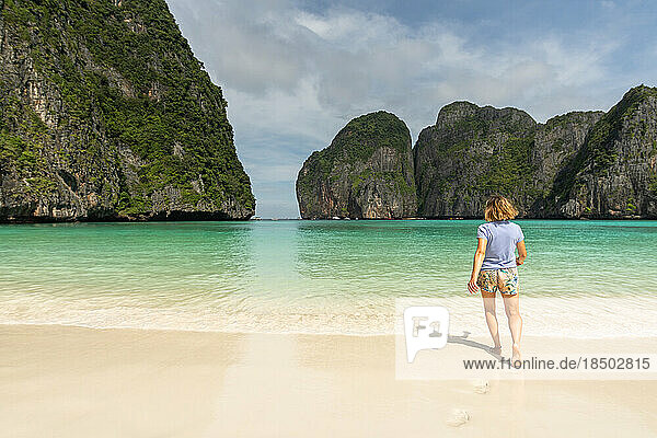 Woman walking on the lonely beach of maya bay