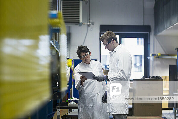 Two engineers looking at report in an industrial plant  Freiburg Im Breisgau  Baden-Württemberg  Germany