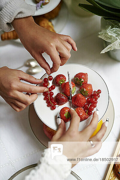 Hands helping themselves to delicious looking fruit platter