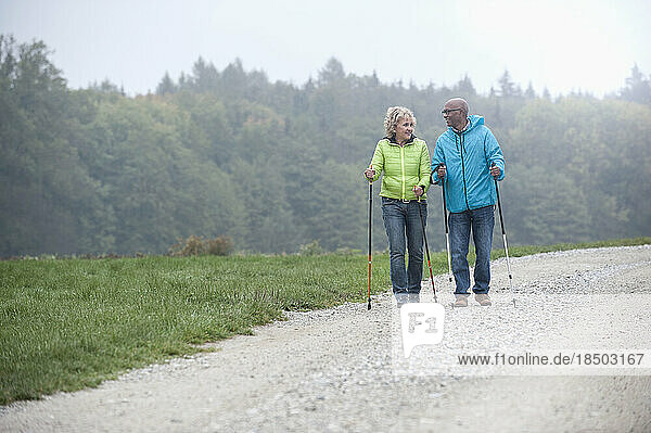 Senior couple hiking with hiking poles  Bavaria  Germany