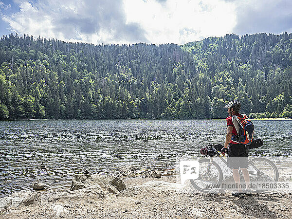 Mountain biker resting at lake Feldsee near Mt Feldberg  Baden-Württemberg  Germany