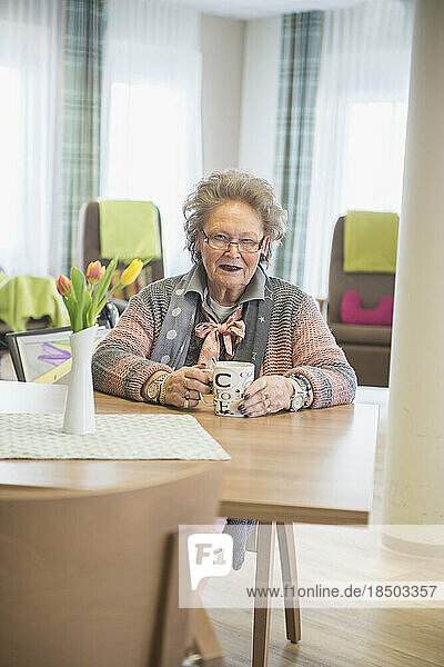 Senior woman with coffee at rest home