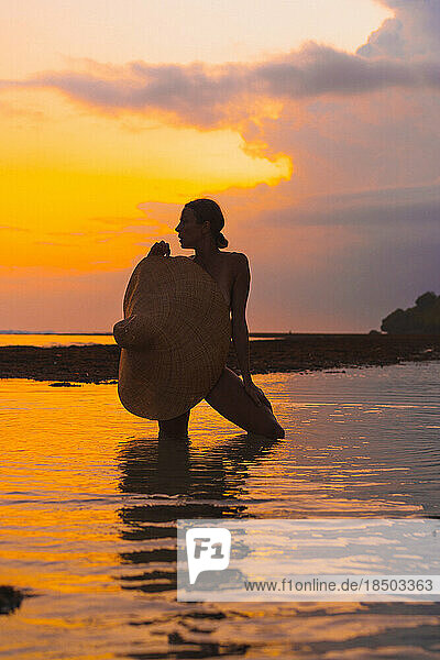 Woman on the ocean at a bright sunset.