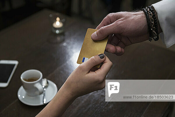 Woman paying bill through credit card at restaurant