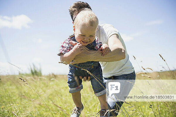 Happy man playing with his son in the countryside  Bavaria  Germany