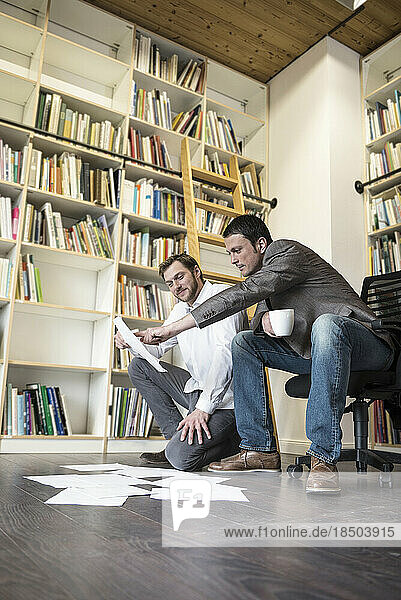 Two businessmen looking at notes in an office  Bavaria  Germany
