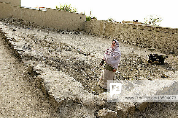 Woman stands on lot where she will build a preschool in Kabul.
