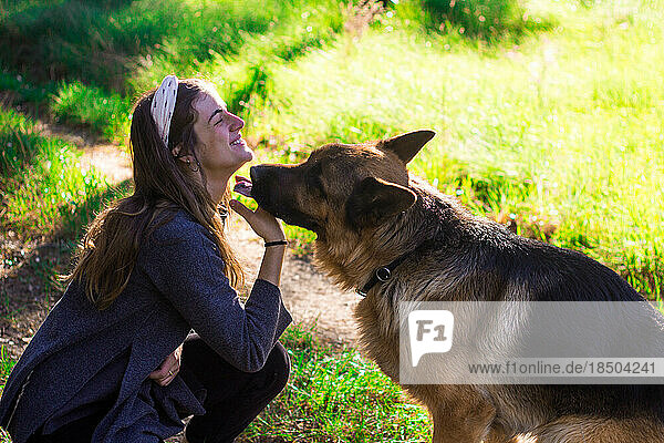 girl kissing with her dog in nature
