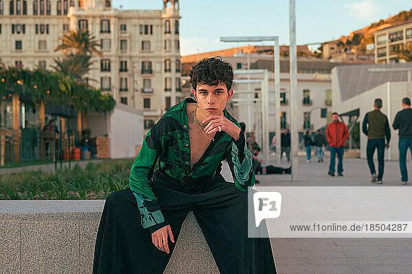 Stylish alternative youth man poses in a city looking at camera