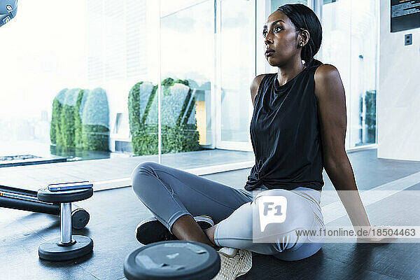 Portrait confident black woman resting at gym