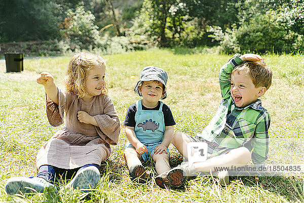 Straight on portrait of three kids playing and laughing together