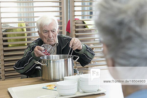Senior man preparing food in rest home