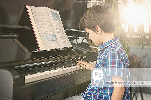 Boy playing piano  Munich  Germany