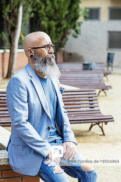 bearded man sitting in a park relaxing