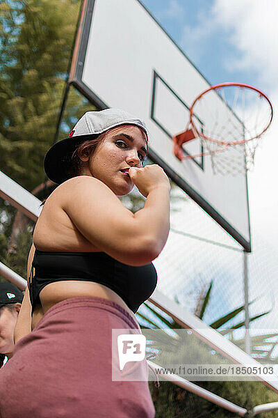 Young woman is in front of a basketball basket  sport concept
