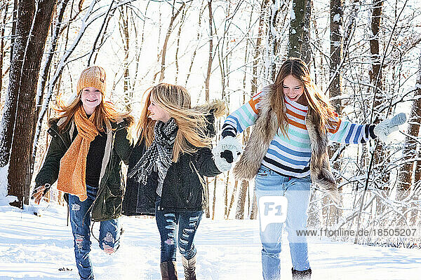 Three happy  beautiful teen girls outdoors in the snow.