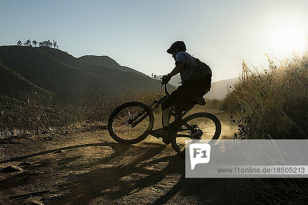 Mature Man riding mountain bike on trail in San Diego  California