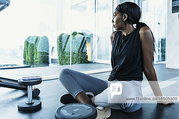 Portrait confident black woman resting at gym
