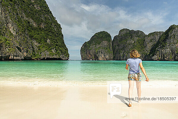 Woman walking on the lonely beach of maya bay