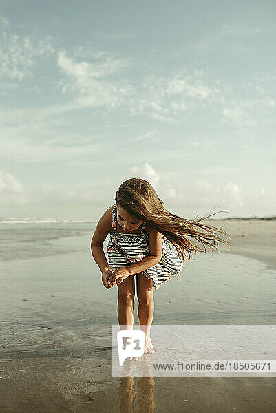 Little Girl looking for shells on the beach in Corpus Christi Texas