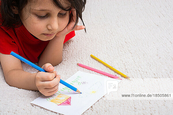 Cute little boy drawing creative drawings at home