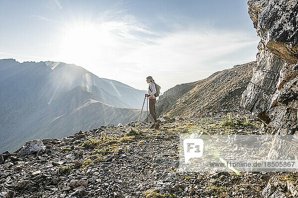 A young woman trail runner takes a break high up on Arapaho Pass