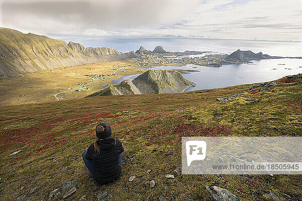 Woman Sitting On A Hill Looking At The Bay In Vaeroy  Lofoten Is