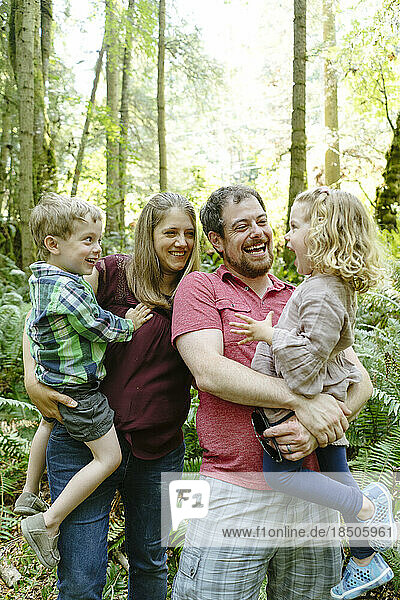 Straight on closeup view of a family laughing together in the forest