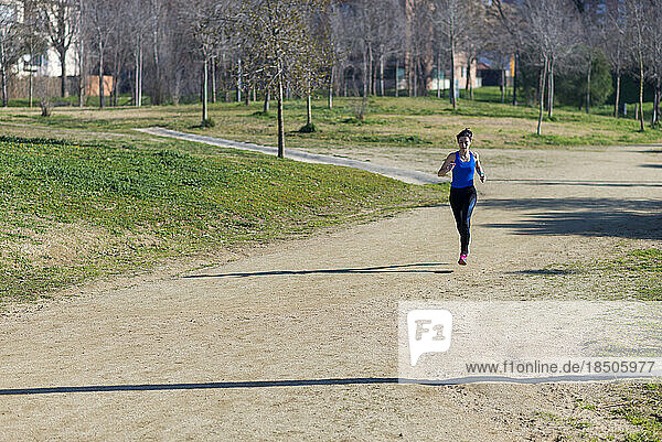 Woman with ponytail running in a park in a sunny day