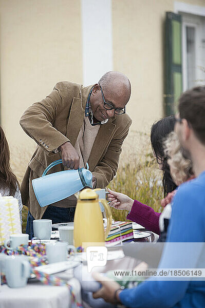 Black man serving coffee at family party  Bavaria  Germany
