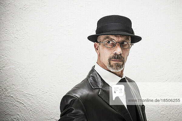 Portrait of a suspicious mature man wearing a hat  Munich  Bavaria  Germany